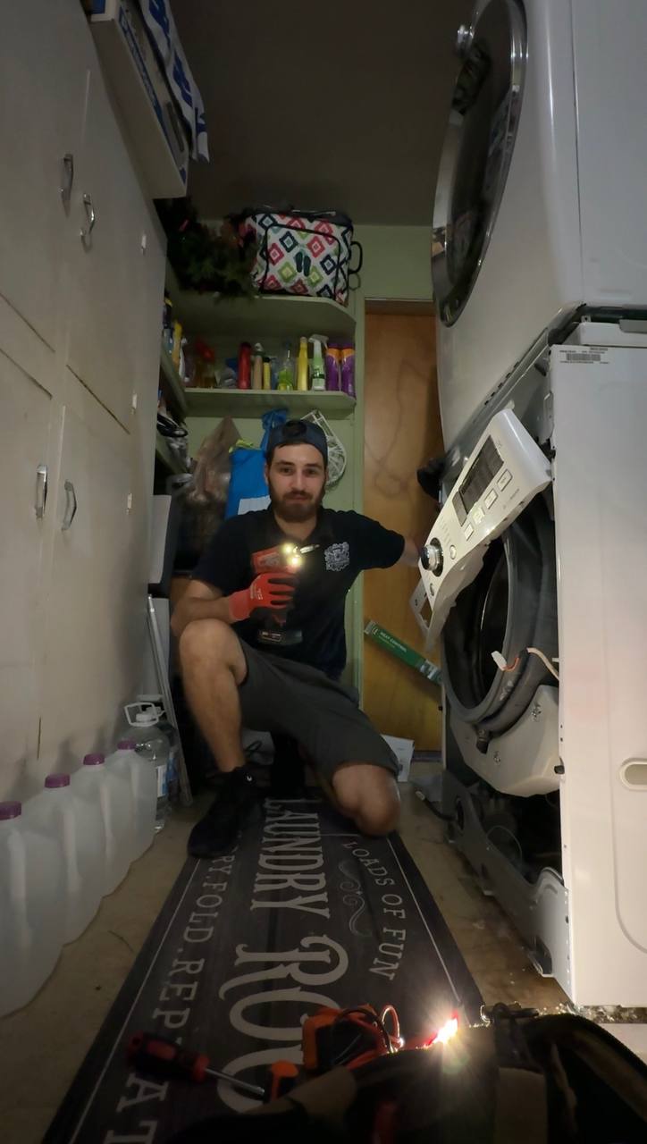 Technician repairing washer in customer laundry room